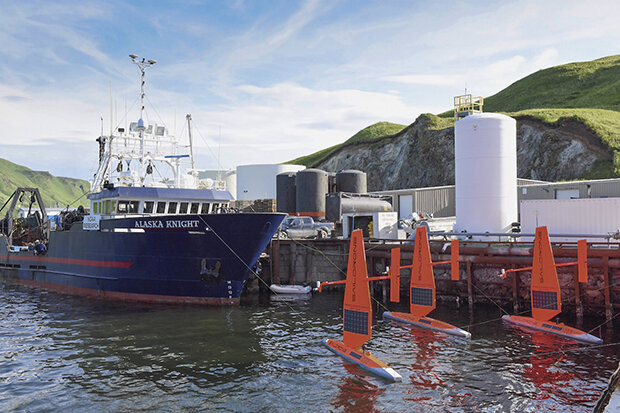 Three drones docked by a larger ship